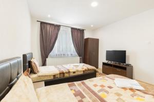 a hotel room with two beds and a flat screen tv at Къща за гости Мечта in Yagodina