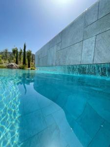 a pool of water next to a stone wall at Casa Paradisu in LʼÎle-Rousse