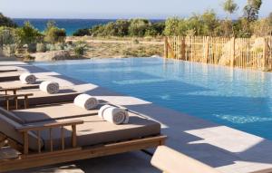 a row of chaise lounges sitting next to a swimming pool at Casa Paradisu in LʼÎle-Rousse