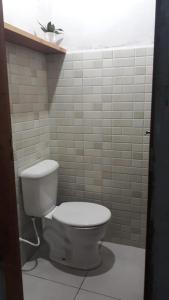 a white toilet in a bathroom with white tiles at Casa Corumbau temporada Recanto Ipê-Amarelo a 400m da praia in Corumbau