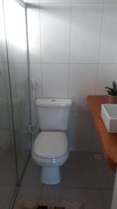 a white bathroom with a toilet and a sink at Casa Corumbau temporada Recanto Ipê-Amarelo a 400m da praia in Corumbau