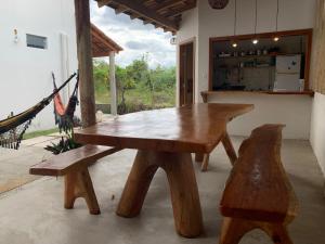 a wooden table and two benches in a room at Casa Corumbau temporada Recanto Ipê-Amarelo a 400m da praia in Corumbau
