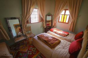 a bedroom with two beds and a mirror at Gîte Atlas Mazik in Imlil