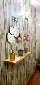 ein Regal mit Platten und Vasen an einer Wand in der Unterkunft Cantinho do Auka - Studio in Aveiro