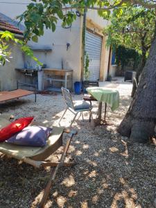 a backyard with a table and a table and a chair at Maison Gemenos in Gémenos