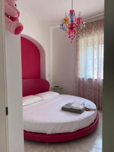 イスキアにあるCasa Pisacaneのベッドルーム1室(ピンクのヘッドボード付きの大型ベッド1台付)