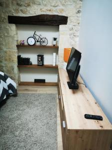 a room with a wooden table with a tv on it at APPARTEMENT COSY LIBOURNE in Libourne