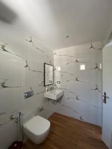 萨兰达Seafront Rooms - Private Beach Access的带马桶和水槽的浴室