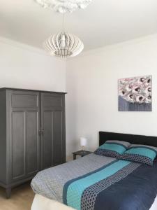 een slaapkamer met een bed en een kroonluchter bij Ernella in Bastia