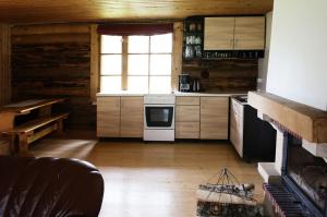 a kitchen with a stove and a window at Aasa Holiday Homes in Kärsu