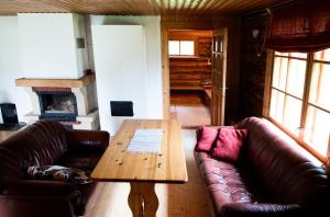 a living room with two leather couches and a wooden table at Aasa Holiday Homes in Kärsu