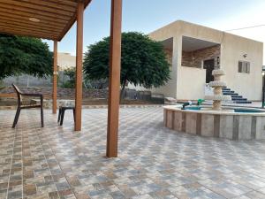 a patio with a fountain and a chair in front of a house at مزرعة النجم Najem farm in Ad Dimnah