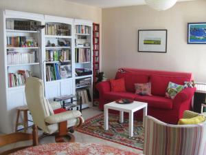 サン・マロにあるChambre d'hôtes les pivoinesのリビングルーム(赤いソファ、本棚付)