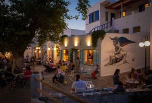 a group of people sitting outside of a building at GUEST HOUSE KALLIOPI in Kómi