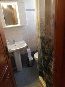 a bathroom with a sink and a toilet and a mirror at GUEST HOUSE KALLIOPI in Kómi