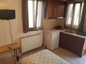 a small kitchen with a sink and a refrigerator at GUEST HOUSE KALLIOPI in Kómi