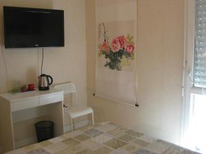サン・マロにあるChambre d'hôtes les pivoinesのベッドルーム(壁にテレビ付)、椅子が備わります。