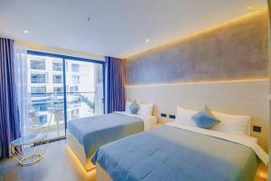 Habitación de hotel con 2 camas y ventana en Apec Sunsea Condotel Phu Yen, en Liên Trì (3)