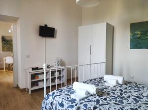 - une chambre avec un lit et une télévision murale dans l'établissement Appartamento La Rampa, à Bénévent
