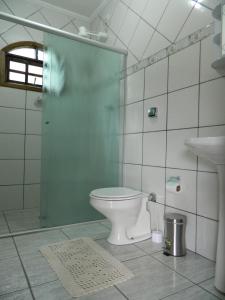 uma casa de banho com um WC, um chuveiro e um lavatório. em Pousada Caruaru em Socorro