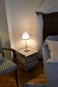 ein Tisch mit einer Lampe neben einem Bett in der Unterkunft Le Petit Massigny in Velluire