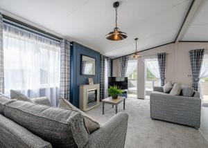 a living room with two couches and a tv at Green Meadows Country Park in Harker