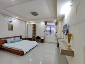 a bedroom with a bed and a desk in it at Winter Spring Homestay Center in Can Tho