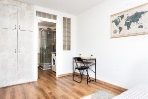 a white bedroom with a desk and a world map on the wall at APPART PREMIUM DU LYS Balcon amenage Parking gratuit in Dammarie-lès-Lys