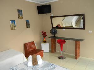 a bedroom with a bed and a mirror and a chair at Pousada Caruaru in Socorro