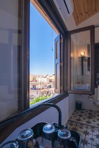 a bathroom with a sink and a window with a view at Marthas DeLight Rooms in Chania