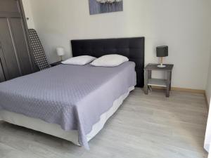 um quarto com uma cama com uma cabeceira preta e uma mesa em Ernella em Bastia