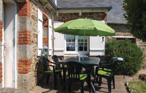 une table et des chaises noires avec un parasol vert dans l'établissement Gorgeous Home In Pleubian With Kitchen, à Pleubian 12 autres photos
