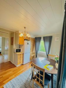 uma cozinha e sala de jantar com mesa e cadeiras em Gula huset em Jomala
