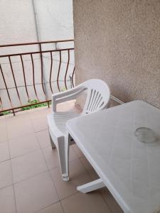 プリモルスコにあるGuest House Mileviの白いテーブル、バルコニー(白い椅子付)