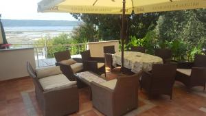 a patio with a table and chairs and an umbrella at Rooms and Apartments Roza in Portorož