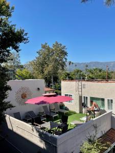 a patio with a table and a red umbrella at Beachside Inn in Santa Barbara