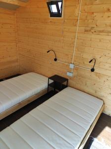 Cette chambre comprend 2 lits et une table. dans l'établissement Parque de Campismo de Fão, à Fão