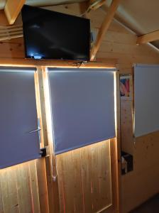 a flat screen tv on a wall with two screens at Parque de Campismo de Fão in Fão