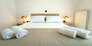 um quarto com uma cama grande e toalhas em Moriana Stone Villa, panoramic view and garden em Lakíthra