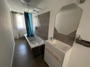 W łazience znajduje się umywalka, wanna i lustro. w obiekcie Relax Sax Appartment w mieście Dinant