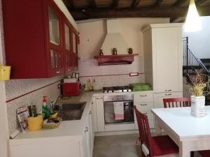 a kitchen with red cabinets and a white counter top at A CA' DI GIO' in Bedizzano