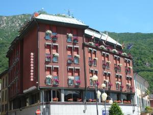 un gran edificio rojo con cajas de flores. en Croce Bianca, en Omegna