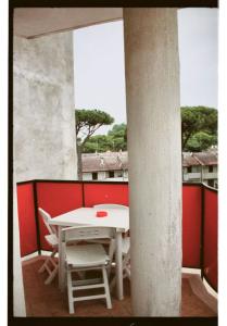 - Balcón con mesa blanca y sillas en Tropicana Residence en Lido degli Estensi