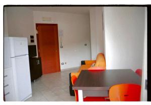 sala de estar con mesa y sillas de color naranja en Tropicana Residence en Lido degli Estensi