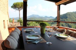 Val di Codena - Holiday Home في Vetto: طاولة مع كؤوس للنبيذ على طاولة مطلة