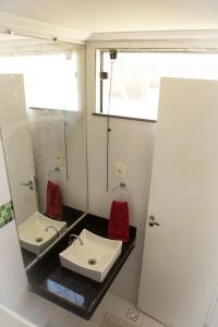La salle de bains est pourvue d'un lavabo et d'un miroir. dans l'établissement Apto na Praia de Guaibim, à Guaibim