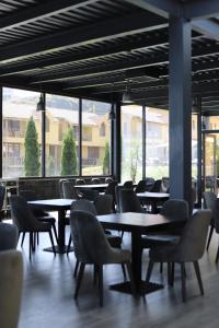 uma sala de jantar com mesas, cadeiras e janelas em Best Western Bohemian Resort em Sevan