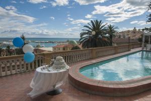 a pool with balloons and a table with a cake on it at Hotel Miramare in Imperia