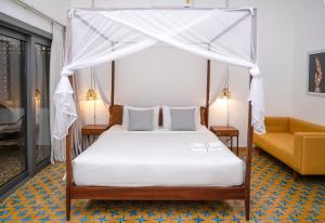 una camera con letto a baldacchino e divano di Jungle Addition a Phnom Penh
