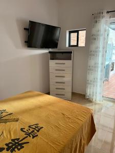 - une chambre avec un lit et une télévision à écran plat dans l'établissement Casa Da Lella, à Guía de Isora